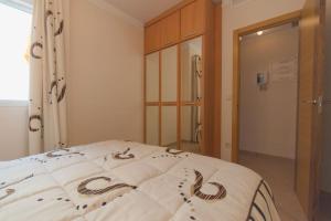 ein Schlafzimmer mit einem Bett mit Design darauf in der Unterkunft 2-Bed Apartment with rooftop pool in Formentera de Segura