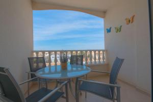 une table bleue et des chaises sur un balcon dans l'établissement 2-Bed Apartment with rooftop pool, à Formentera de Segura