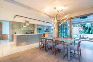 a kitchen and dining room with a table and chairs at Amara Lincoln - 100m From Camps Bay Beach in Cape Town