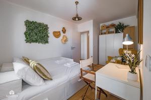 a bedroom with a bed and a desk and a table at The Pateo Beach Apartment - Santa Cruz in Santa Cruz