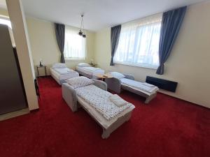 Habitación con 4 camas y alfombra roja. en Figaro Apartaments, en Gdynia