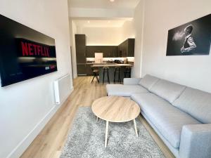 a living room with a couch and a table at Fountain Apartment No 2 with Free Parking in York +11 photos