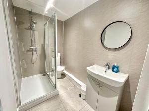 a bathroom with a shower and a sink and a mirror at Fountain Apartment No 2 with Free Parking in York