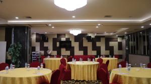 una sala conferenze con due tavoli e sedie rosse di Pakons Prime Hotel a Tangerang Altre 37 foto