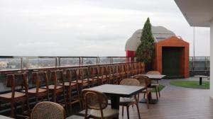 una fila di tavoli e sedie su un balcone di Pakons Prime Hotel a Tangerang