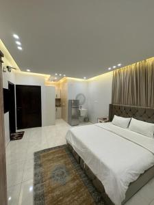 a bedroom with a large bed and a television at دارك للوحدات السكنية in ‘Aryam