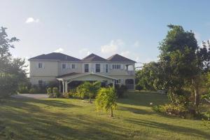 a large white house with a large yard at J's Oasis in Nevis
