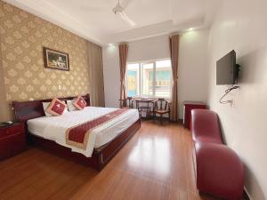 een hotelkamer met een bed en een stoel bij Khách Sạn Kim Cương Thái Bình in Thái Bình