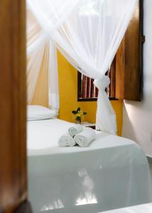 a bedroom with a bed with towels on it at Pousada Tortuga in Barra Grande