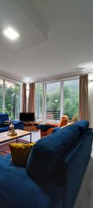 a living room with a blue couch and a large window at Anur Apartment in Bihać
