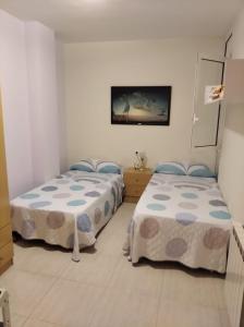 1 dormitorio con 2 camas y TV en la pared en Isaac, en Figueres