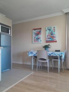 a kitchen with a table with chairs and a refrigerator at Sugarbush Accommodation in Vereeniging