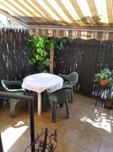 un patio con mesa, sillas y una valla en Isaac, en Figueres