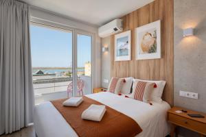 a bedroom with a large bed with a large window at Hotel Made inn Faro in Faro