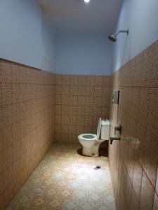 a bathroom with a toilet in a tiled room at Hotel Maerakatja Yogyakarta in Jetis