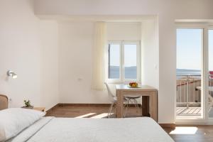 a bedroom with a bed and a table and a balcony at Villa LANA*** in Omiš