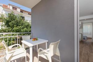a balcony with a white table and chairs at Villa LANA*** in Omiš