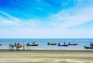 un grupo de barcos en el agua en una playa en Villa Cha Cha Chaolao Beach Resort, en Chao Lao Beach