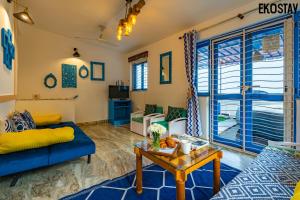 a living room with a blue couch and a table at EKOSTAY - Athens Villa with Jacuzzi in Baga