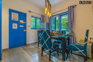 a dining room with a blue door and a table and chairs at EKOSTAY - Athens Villa with Jacuzzi in Baga