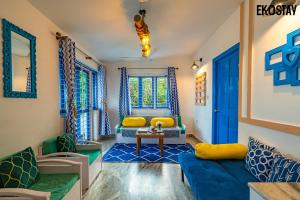 a living room with a blue couch and yellow pillows at EKOSTAY - Athens Villa with Jacuzzi in Baga