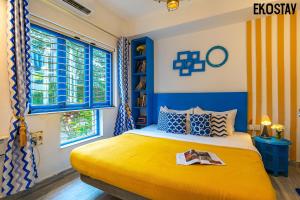 a blue and yellow bedroom with a bed and a window at EKOSTAY - Athens Villa with Jacuzzi in Baga