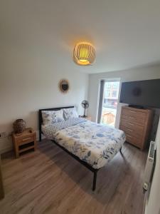 a bedroom with a bed and a lamp and a window at lovely new home in manchester close to MANCHESTER CITY FC in Manchester