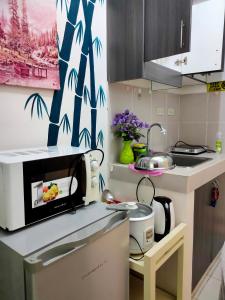 a kitchen with a microwave on a counter at Tagaytay Condo Staycation in Iruhin +5 photos