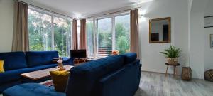 a living room with blue couches and a large window at Anur Apartment in Bihać