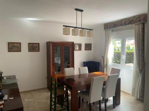 a dining room with a wooden table and white chairs at Manilva Beach: Your Costa del Sol Getaway! in Castillo de Sabinillas