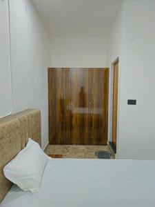 a bedroom with a bed and a shower in a room at Motel Ilika in Bilāspur