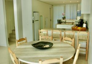 a kitchen with a table and chairs and a kitchen with a counter at La Menina Mole Beachfront House! 4BR/4,5Baths in Florianópolis