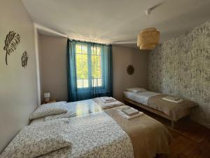 una camera da letto con due letti e una finestra di Le gîte du port canal a Moissac