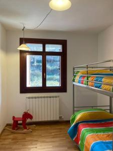 Azarrulla的住宿－Bonito apartamento en Ezcaray，一间卧室设有两张双层床,铺有木地板,配有一匹红马。