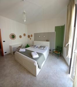 a bedroom with a large bed and a chair at VincesilHouse in Mola di Bari