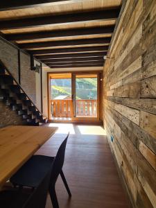 Cette chambre est dotée d'un mur en bois avec une table et une fenêtre. dans l'établissement CMD Méribel, à Méribel