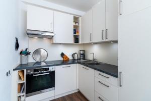 a kitchen with white cabinets and black counter tops at Ohlerich Speicher Ohlerich Speicher 2-09 in Wismar +5 photos