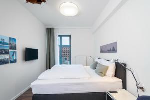 a bedroom with a large white bed and a window at Ohlerich Speicher Ohlerich Speicher 2-09 in Wismar