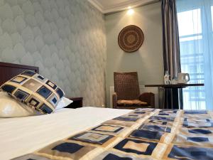 a bedroom with a bed and a chair and a window at African Sky Hotel in Werlte