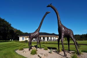 two giraffes statues standing in a yard at African Sky Hotel in Werlte