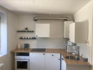 a kitchen with white cabinets and a sink at Beau T3 boulevard de Strasbourg in Le Havre