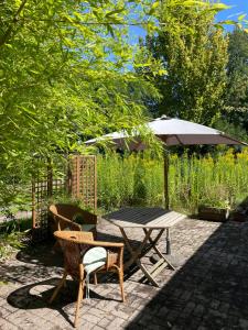 een tafel en stoelen en een parasol in de tuin bij Landhaus im Bremischen in Hagen im Bremischen