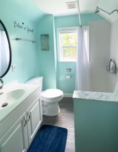 uma casa de banho com um WC, um lavatório e um espelho. em Sunny Queen bedroom feel like home!! em Englewood