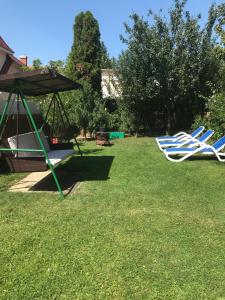 due sedie da giardino e un ombrellone in un cortile di Veronika Apartman a Hévíz