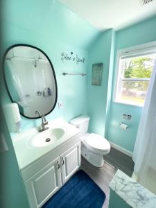 uma casa de banho com um espelho, um lavatório e um WC. em Sunny Queen bedroom feel like home!! em Englewood