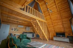 a living room with a wooden ceiling with a staircase at Aronia Bungalow in Elmalık