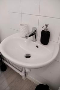 a white bathroom sink with a soap dispenser on it at Lava Studio in Poitiers