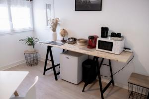 una cocina con mesa y microondas. en Lava Studio en Poitiers