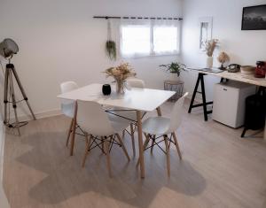 a dining room with a white table and white chairs at Lava Studio in Poitiers