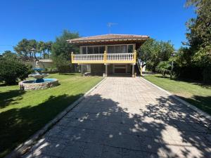 a house with a porch and a fountain in a yard at Villa Nogueroles in Sanchidrián